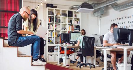 Coworkers using computers at office